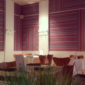 The minimalist look of the restaurant with shots of bright coloured wallpaper!