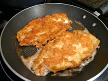 The battered sole being pan-fried.